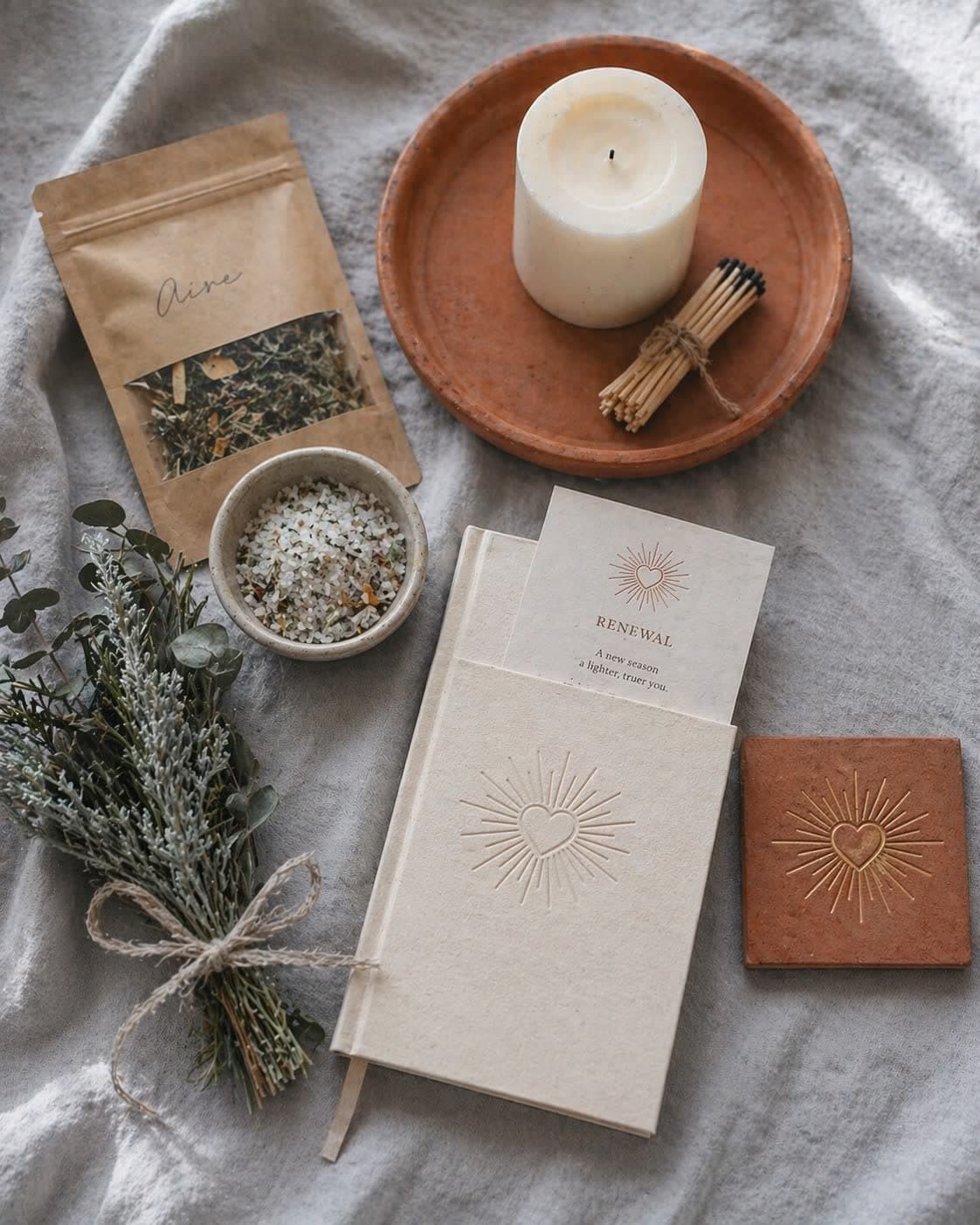 An open Casa Box with Luz candle, blessing salts, hand-embossed journal, simmer blend pouch, and terracotta tile keepsake — a seasonal home ritual arrived.